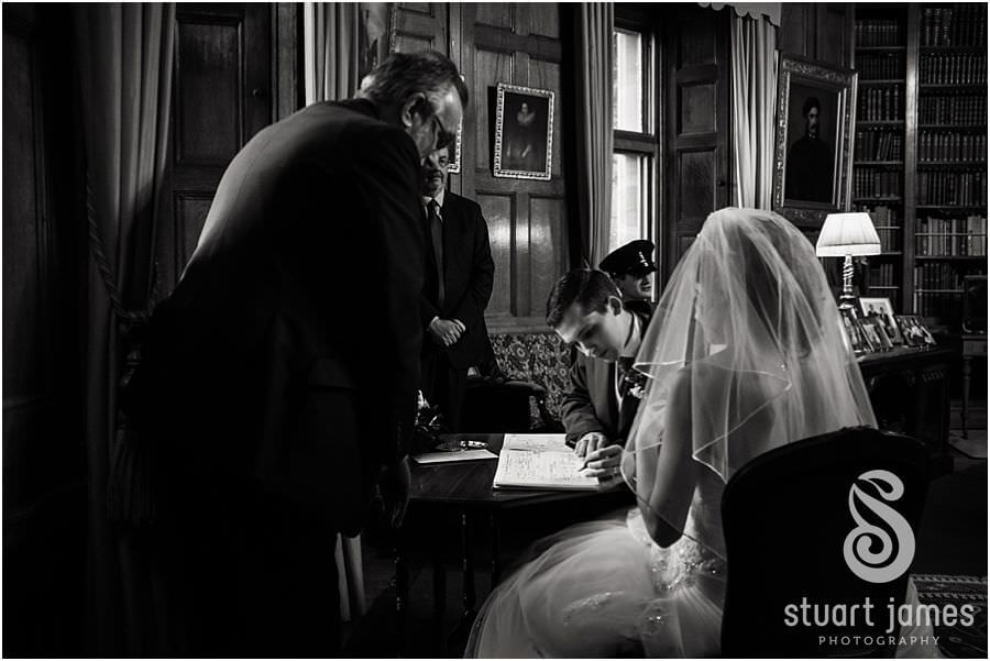 Bride and groom exchange rings in Library at Muncaster Castle in Ravenglass by Wedding Photojournalist Stuart James