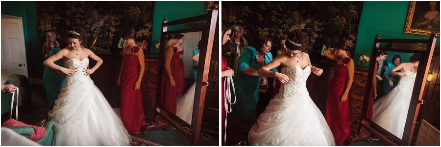 Bride photographed getting into her dress at Muncaster Castle in Cumbria by Documentary Wedding Photographer Stuart James