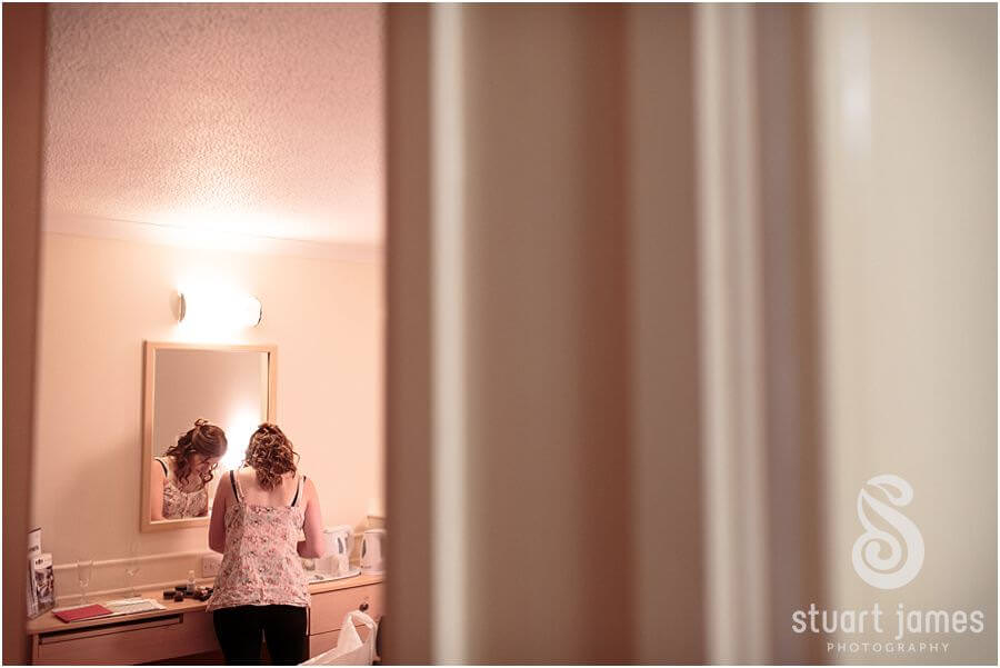 Candid photography of bridal hair and makeup preparations at hotel before wedding at Twycross Zoo in Atehrstone by Warwickshire Wedding Photographer Stuart James