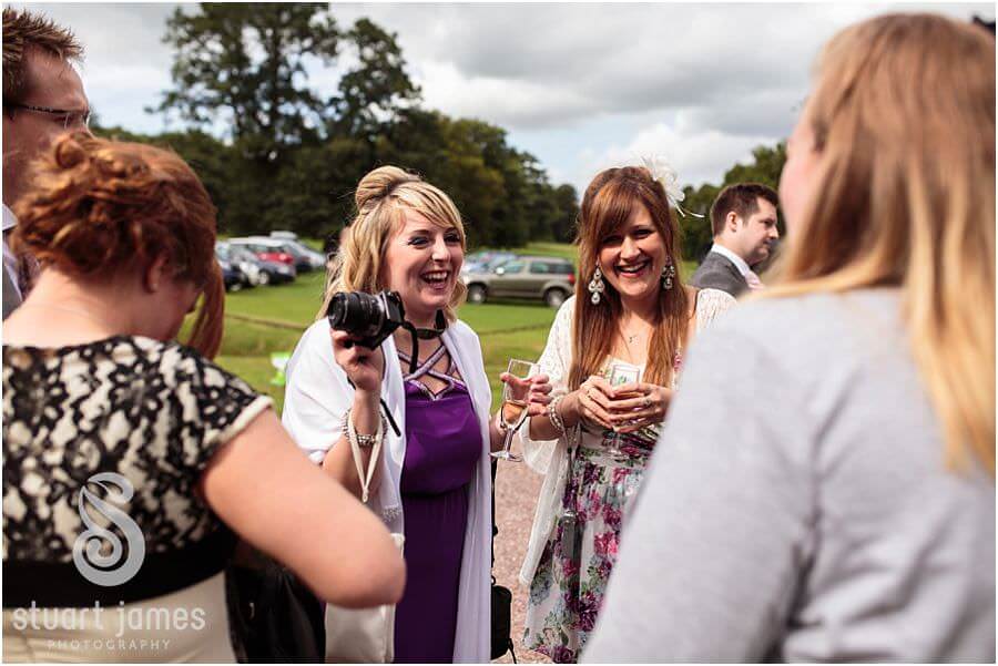Candid wedding photographs of guests enjoying wedding at Sandon Hall near Stafford by Eccleshall Wedding Photographer Stuart James