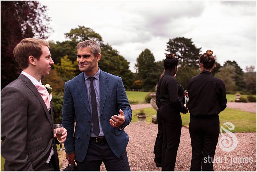 Candid photographs of guests enjoying the drinks reception at Sandon Hall near Stafford by Stafford Wedding Photographer Stuart James