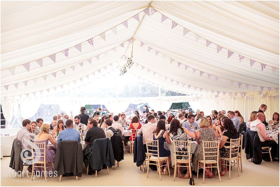 Candid photographs of the wedding guests enjoying the wedding breakfast in the setting of Bride's parents home near Chaddesley Corbet by Reportage Wedding Photographer Stuart James
