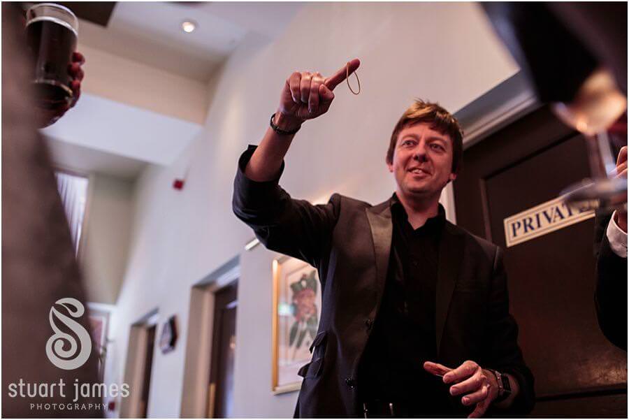 Candid photographs of guests being entertained by close magician at Moor Hall near Sutton Coldfield by Sutton Coldfield Reportage Wedding Photographer Stuart James