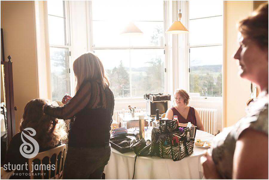 Reportage photos of the bride getting ready with her bridesmaids in the bedroom at Sandon Hall in Stafford by Documentary Wedding Photographer Stuart James