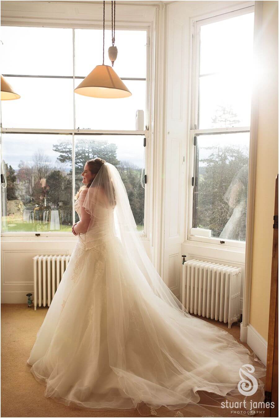 Elegant bridal window portrait at Sandon Hall in Stafford by Documentary Wedding Photographer Stuart James