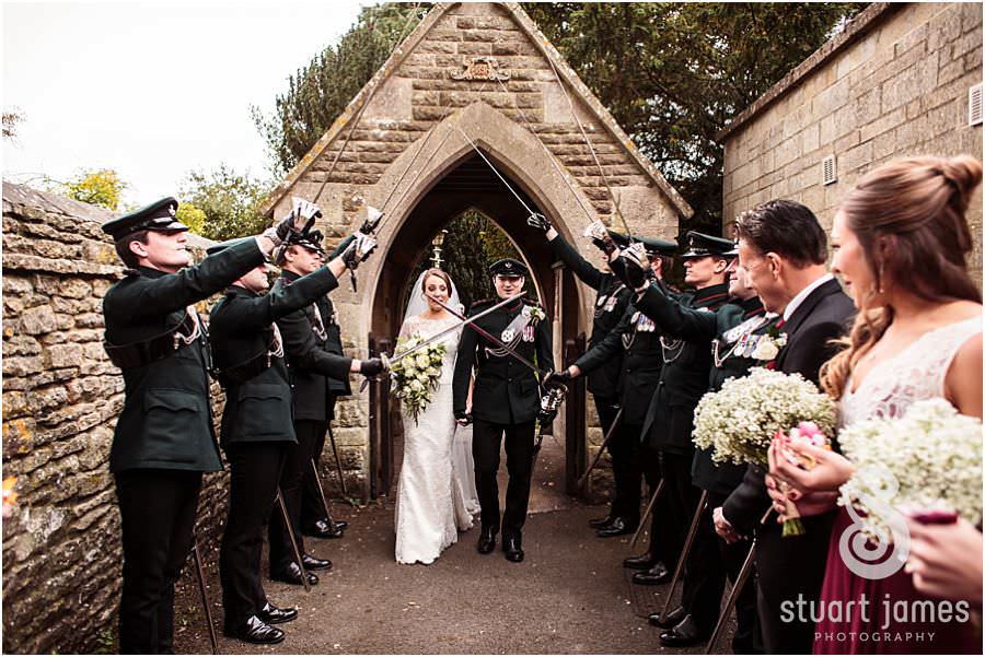 Fabulous exciting exit to Guard of Honour and confetti at St Marys Church in Cogges by Documentary Wedding Photographer Stuart James