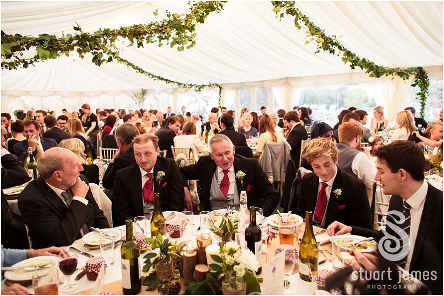 Laughter and enjoyment during the wedding breakfast at Oxleaze Barn in Gloucestershire by Documentary Wedding Photographer Stuart James