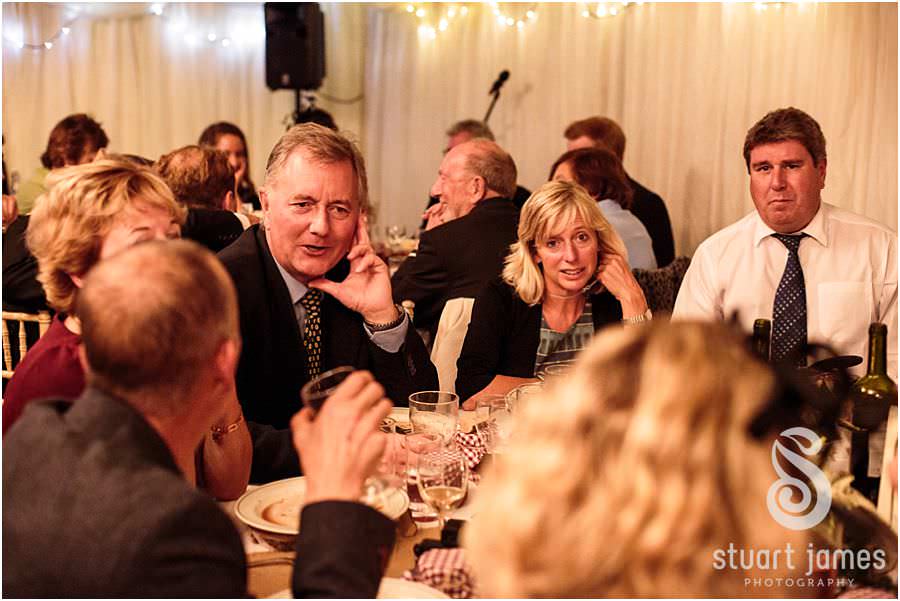 Laughter and enjoyment during the wedding breakfast at Oxleaze Barn in Gloucestershire by Documentary Wedding Photographer Stuart James