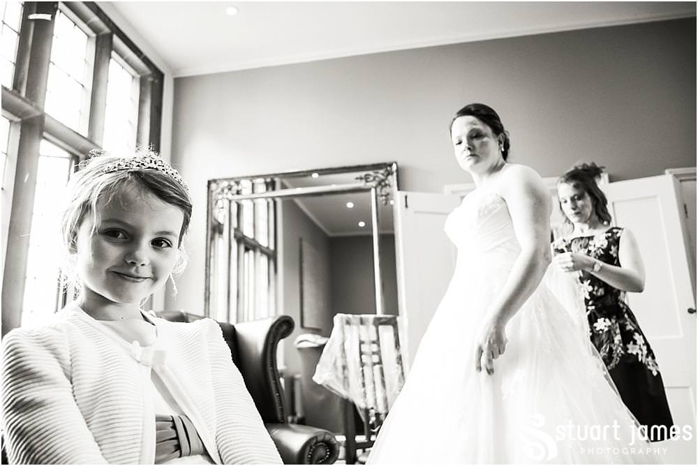 Gorgeous photographs of the bride and grooms daughter being central to the finishing preparations in Love is Enough at Pendrell Hall in Codsall, Wolverhampton by Pendrell Hall Wedding Photographers Stuart James