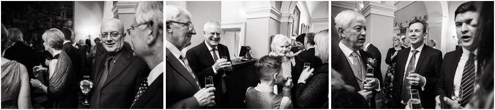 Reportage photographs of the guests enjoying the drinks reception in the marble hallway
