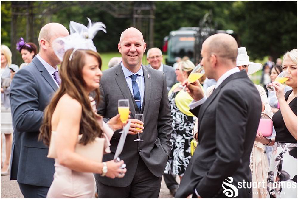 Candid photographs of the guests enjoying the drinks reception at Sandon in Staffordshire by Documentary Wedding Photographer Stuart James
