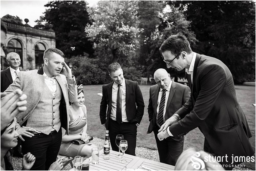 Close magic fun with Chris Peskett as he entertains the guests at Sandon in Staffordshire by Documentary Wedding Photographer Stuart James