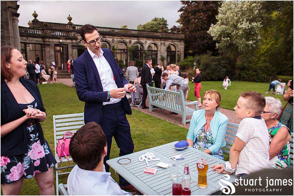 Close magic fun with Chris Peskett as he entertains the guests at Sandon in Staffordshire by Documentary Wedding Photographer Stuart James