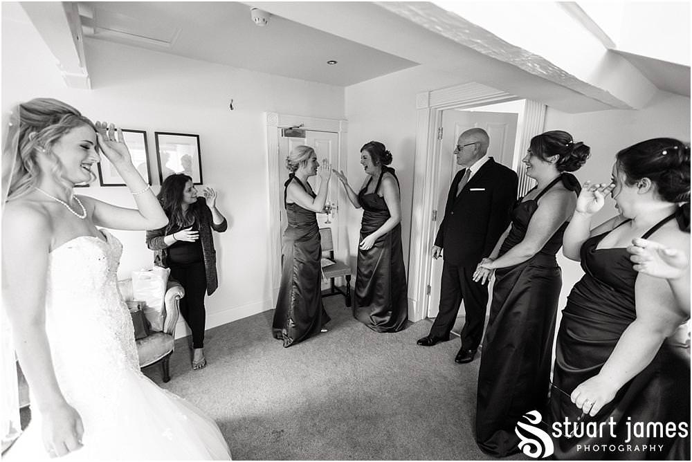Documenting the beautiful and emotional reactions as the bride reveals her gown at Warwick House in Southam by Documentary Wedding Photographer Stuart James