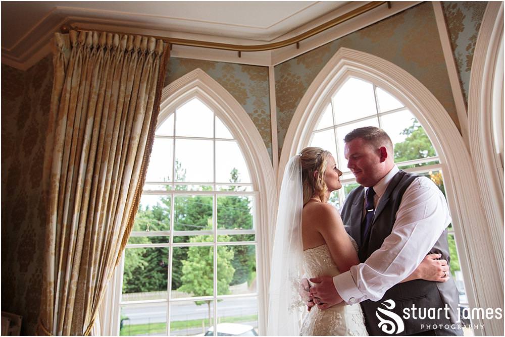 Utilising the stunning windows at Warwick House in Southam for creative evening portraits with the bride and groom captured by Documentary Wedding Photographer Stuart James