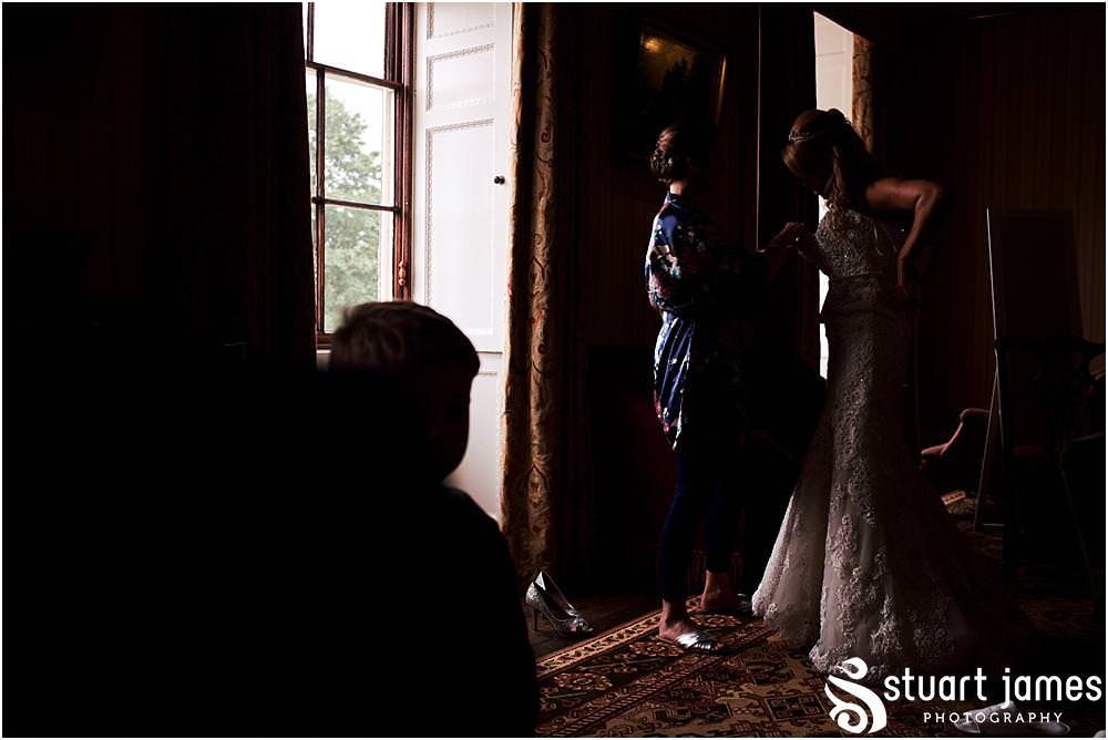 Finishing scenes as the bride dresses in her beautiful Maggie Sottero dress at Weston Park in Staffordshire by Documentary Wedding Photographer Stuart James