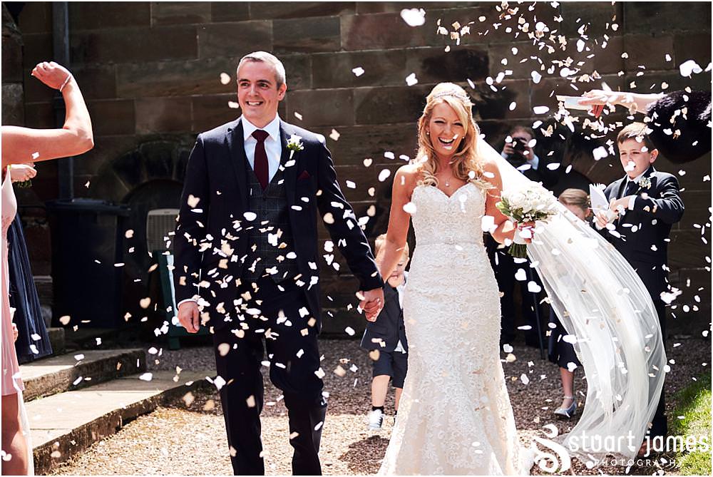Confetti exit from the ceremony at St Andrews Church in Weston Park, Staffordshire by Documentary Wedding Photographer Stuart James