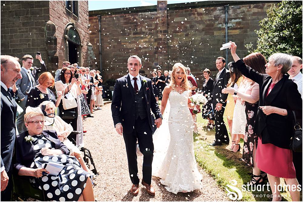 Confetti exit from the ceremony at St Andrews Church in Weston Park, Staffordshire by Documentary Wedding Photographer Stuart James