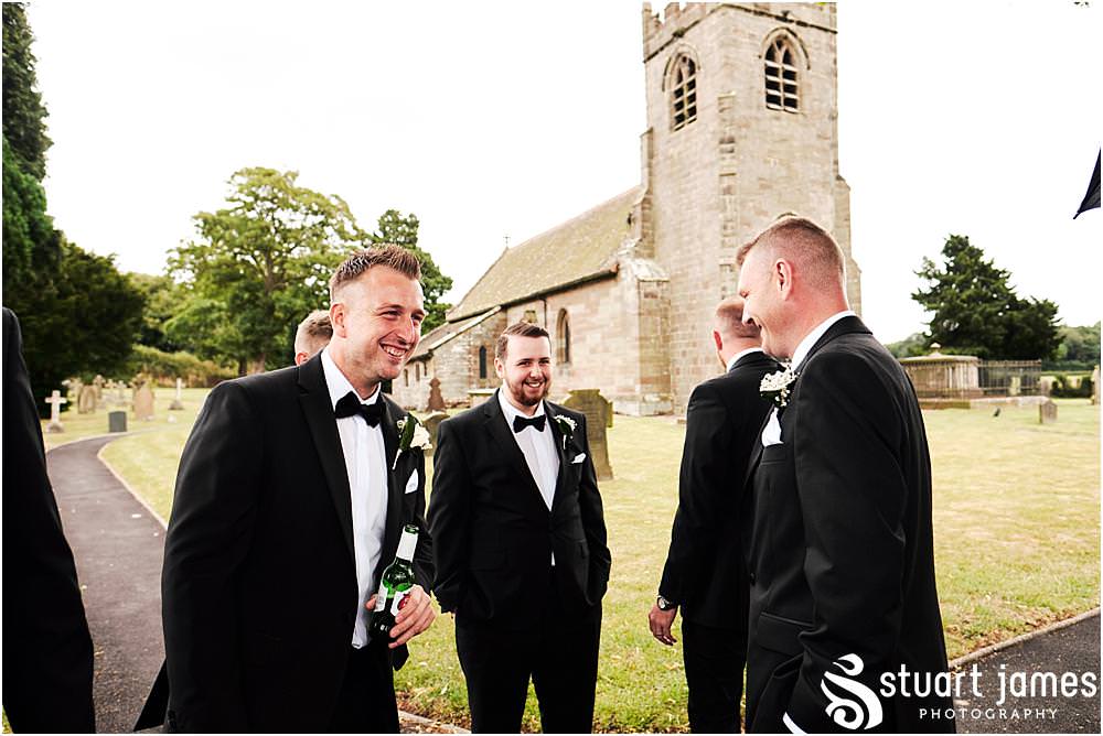 Candid photographs of the groomsmen greeting the guests at St James Church in Acton Trussell by Documentary Wedding Photographer Stuart James