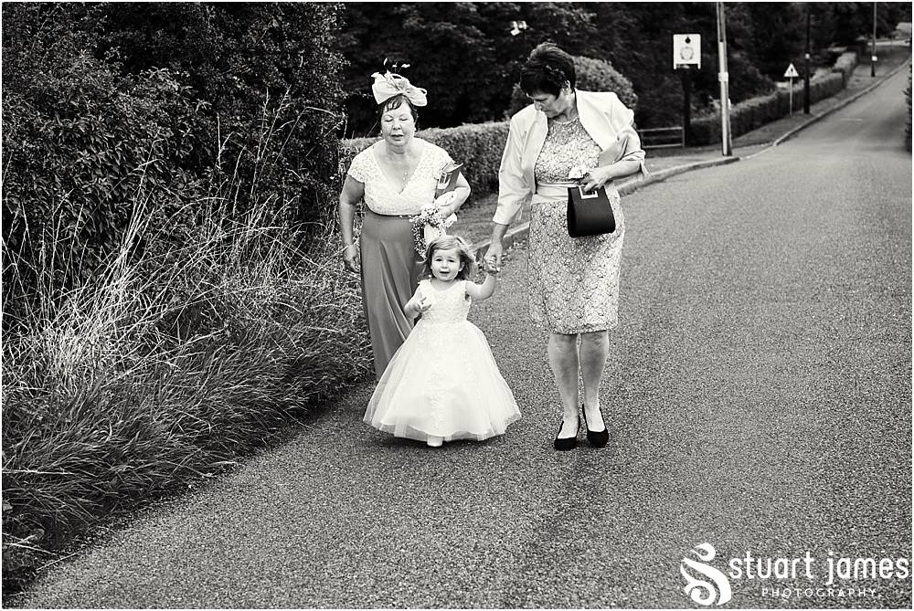 Arrival of the beautiful flower girl with her grandmothers at St James Church in Acton Trussell by Documentary Wedding Photographer Stuart James