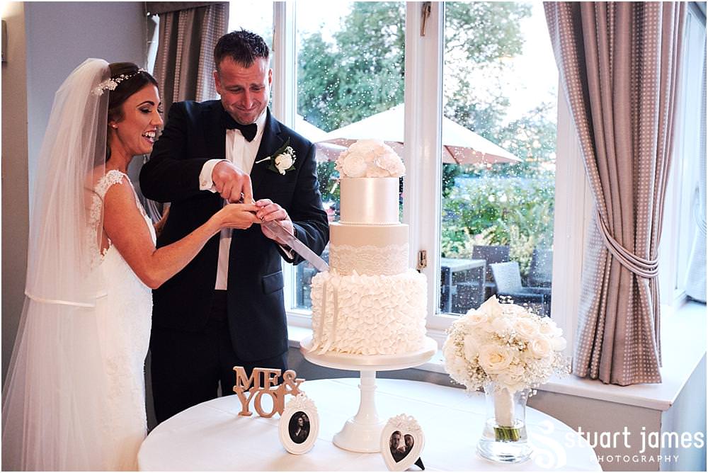 Cutting of the beautiful wedding cake from Amerton Cakes at The Moat House in Acton Trussell by Documentary Wedding Photographer Stuart James