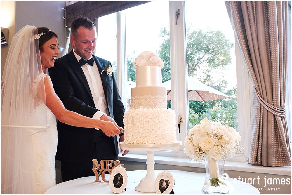 Cutting of the beautiful wedding cake from Amerton Cakes at The Moat House in Acton Trussell by Documentary Wedding Photographer Stuart James