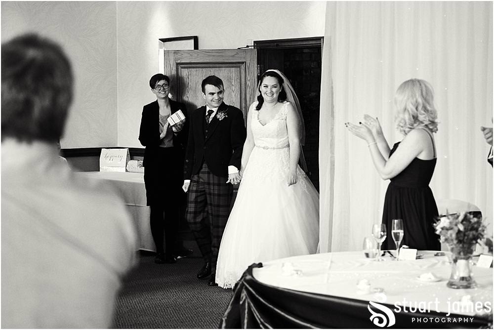 Photograph of the wonderful moment the Bride and Groom enter to their awaiting guests at The Moat House in Acton Trussell by Documentary Wedding Photographer Stuart James