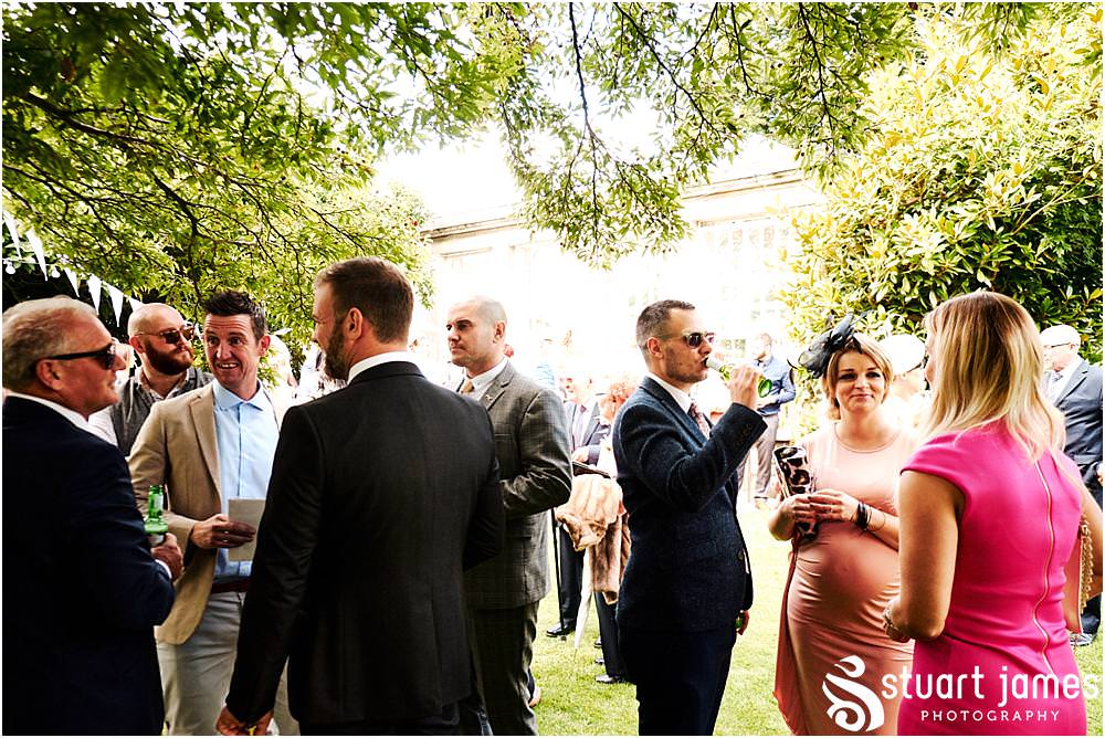 Creative candid photographs of the guests enjoying the fabulous afternoon drinks reception on the lawns at Bishton Hall in Stafford by Documentary Wedding Photographer Stuart James