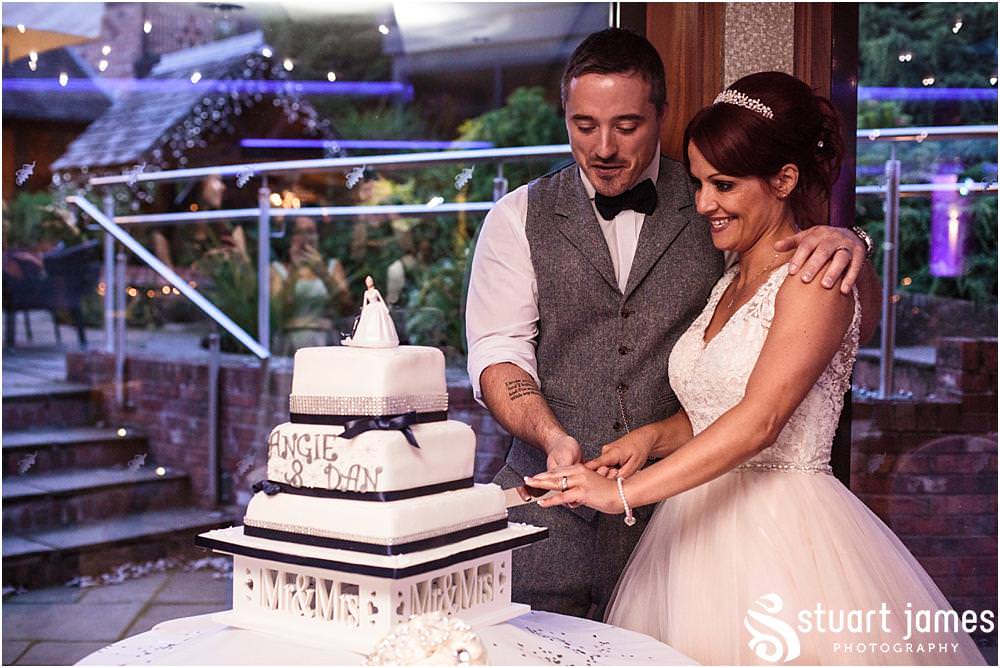 Cake cutting fun at Moddershall Oaks captured by Moddershall Oaks Wedding Photographer Stuart James