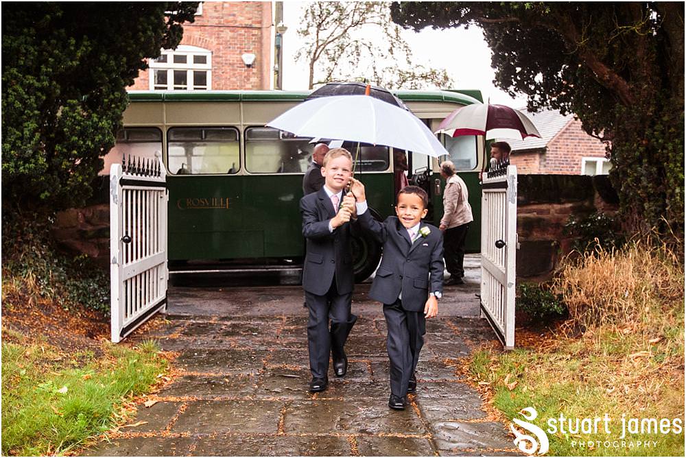 An arrival in the rain, but in some fabulous vintage style, for the wedding at Middleton Church and Moxhull Hall in Sutton Coldfield by Moxhull Hall Wedding Photographers Stuart James