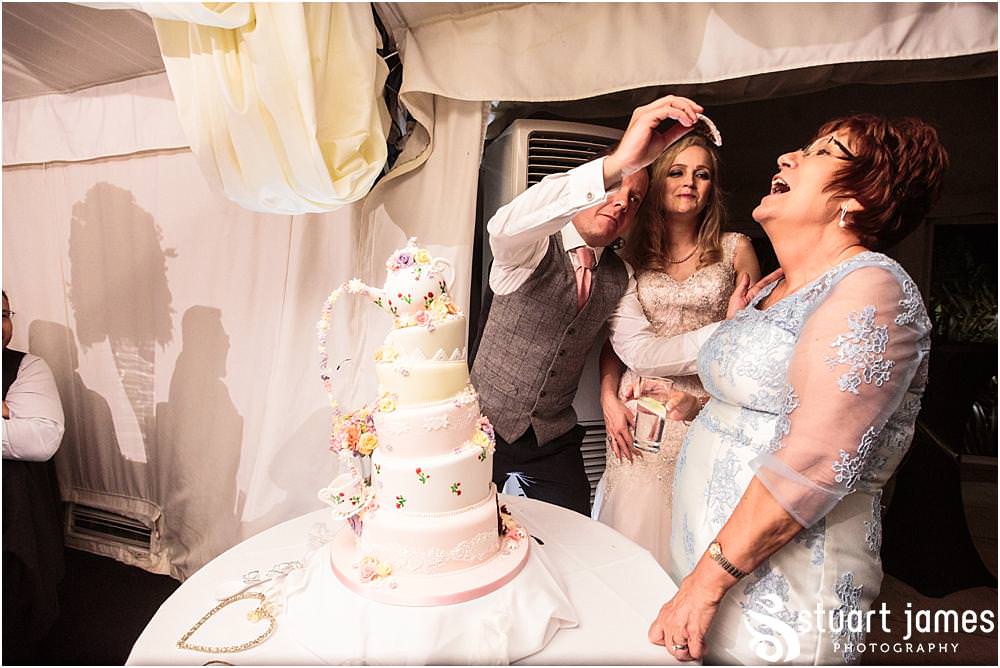 Cake cutting fun at Moxhull Hall in Sutton Coldfield by Moxhull Hall Wedding Photographers Stuart James