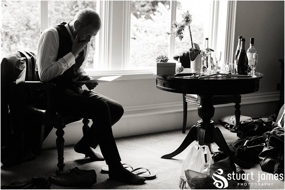Photos of the emotion building for the groom as he opens his present from his bride at Pendrell Hall with Pendrell Hall Wedding Photography by Stuart James