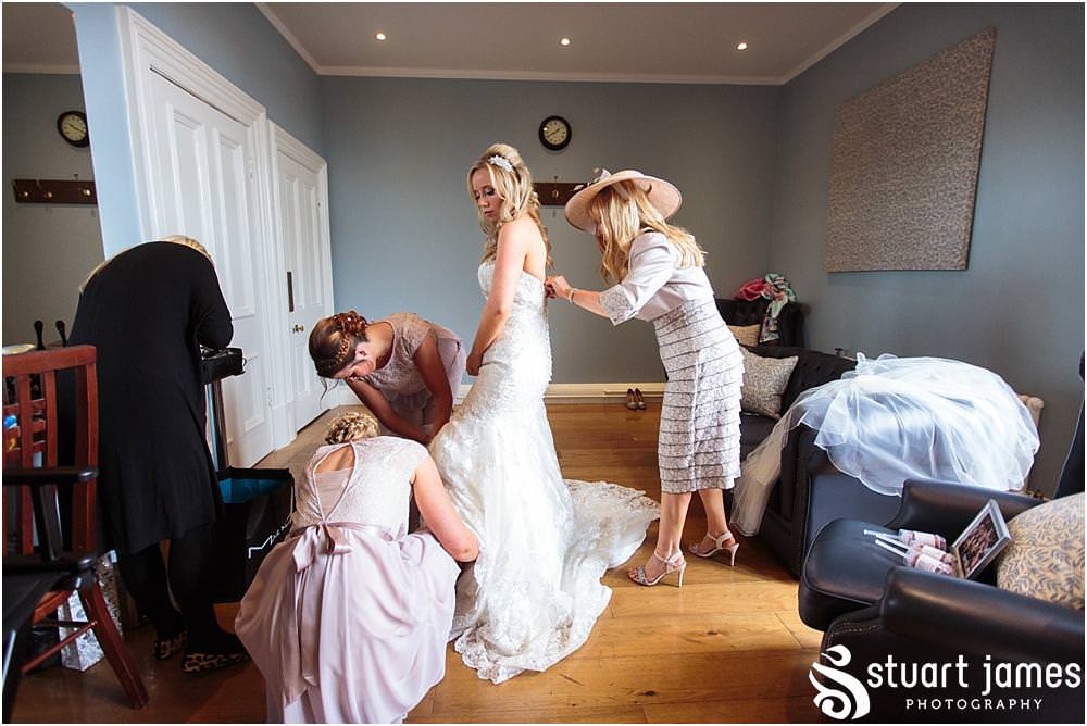 Capturing the finishing touches as our bride enters her stunning wedding gown at Pendrell Hall with Pendrell Hall Wedding Photography by Stuart James