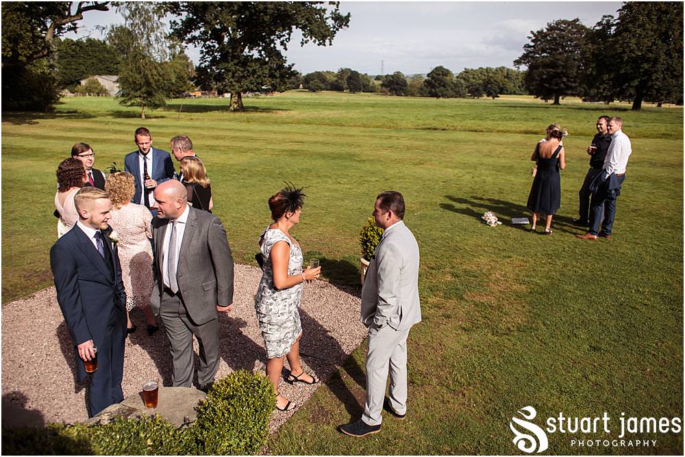 Creative candid photographs capturing the guests enjoying the drinks reception on the lawns at Pendrell Hall with Pendrell Hall Wedding Photography by Stuart James