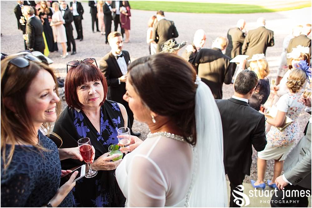 Natural photographs capturing the guests enjoying the drinks reception in the sun at Davenport House in Shropshire by Davenport House Wedding Photographers Stuart James