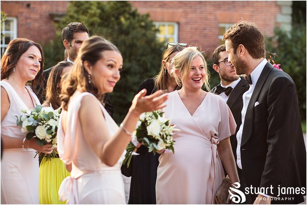 Natural photographs capturing the guests enjoying the drinks reception in the sun at Davenport House in Shropshire by Davenport House Wedding Photographers Stuart James