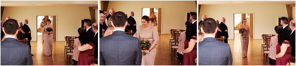 Capturing the emotions and the excitement as the bridal party process into the barn for the wedding ceremony at The Mill Barns in Alveley by Mill Barns Wedding Photographers Stuart James