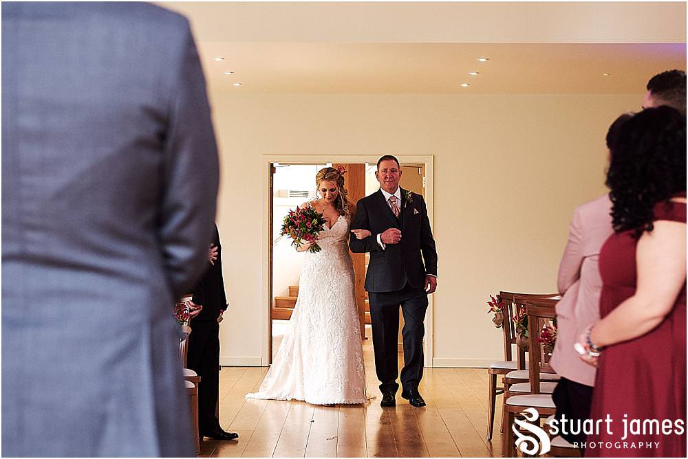 Capturing the emotions and the excitement as the bridal party process into the barn for the wedding ceremony at The Mill Barns in Alveley by Mill Barns Wedding Photographers Stuart James