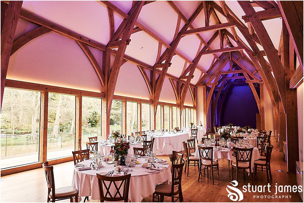 Beautiful floral displays from Lily Jones complimenting the Gin bottles and log centres for the wedding breakfast in The Mill Barns in Alveley by Mill Barns Wedding Photographers Stuart James