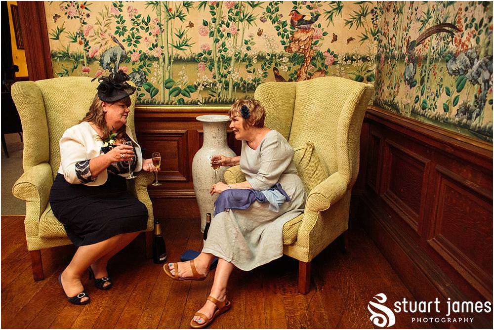 Capturing natural photographs of the guests enjoying the evening reception in the beautiful manor house setting at Sandon Hall in Stafford by Sandon Wedding Photographers Stuart James