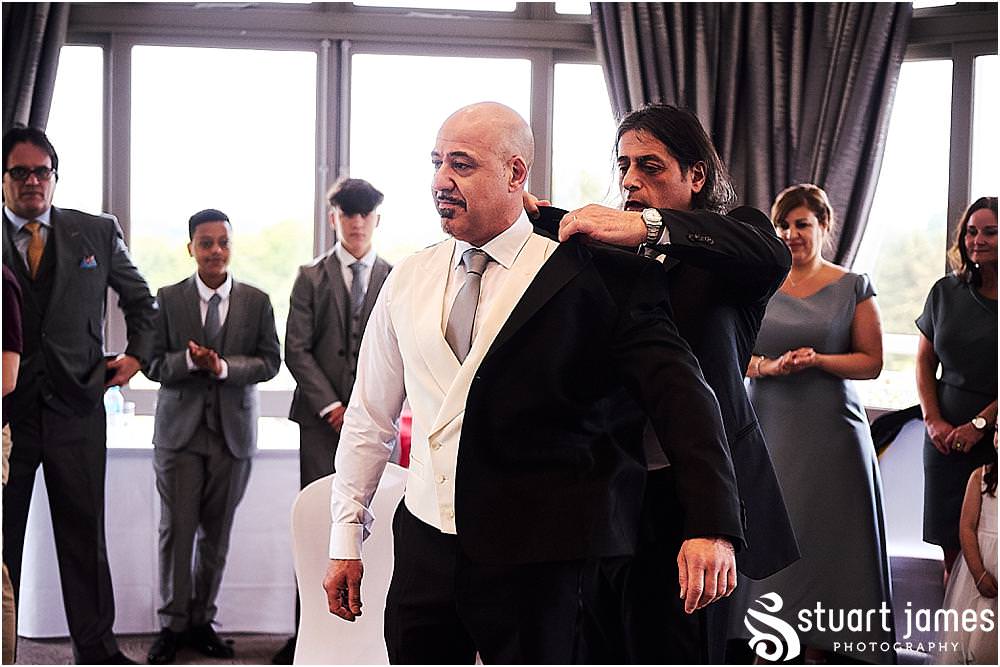 Natural storytelling photographs of the stolisma ceremony for the Groom at The Belfry in Birmingham by Greek Wedding Photographer Birmingham Stuart James