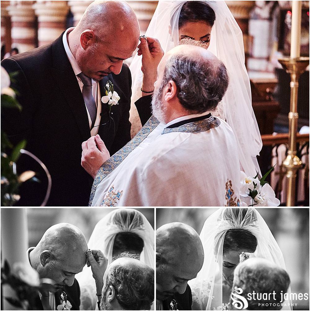 As our bride and grooms rings are blessed and exchanges, the photographer captures beautiful moment at Greek Orthodox Church in Birmingham by Greek Wedding Photographer Birmingham Stuart James
