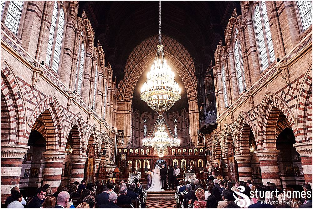 As our bride and grooms rings are blessed and exchanges, the photographer captures beautiful moment at Greek Orthodox Church in Birmingham by Greek Wedding Photographer Birmingham Stuart James