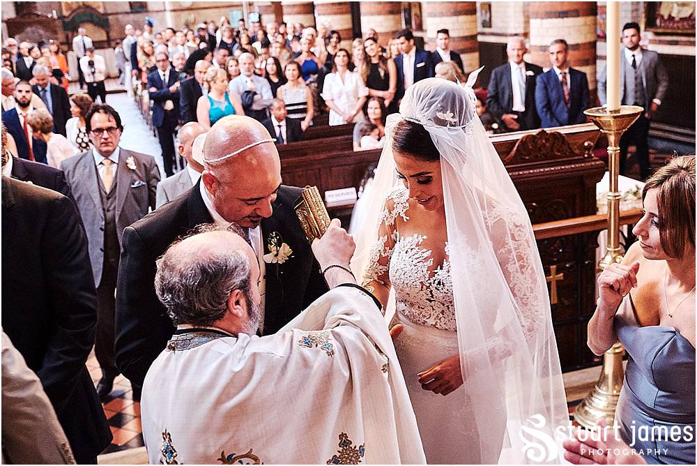As the couple take communion, they officially become husband and wife at Greek Orthodox Church in Birmingham by Greek Wedding Photographer Birmingham Stuart James