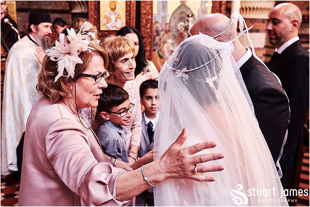 Capturing the scenes of congratulations for the bride and groom at Greek Orthodox Church in Birmingham by Greek Wedding Photographer Birmingham Stuart James