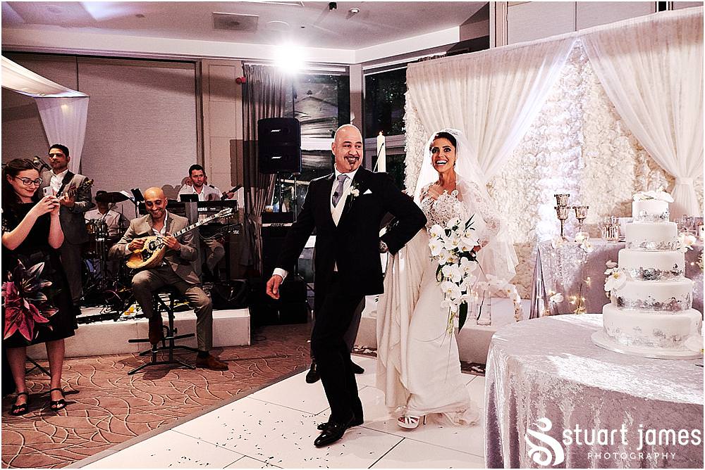 An entrance in style as the Bride and Groom are led into the Woodland Suite by the violinist from the band at The Belfry in Birmingham by Greek Wedding Photographer Birmingham Stuart James