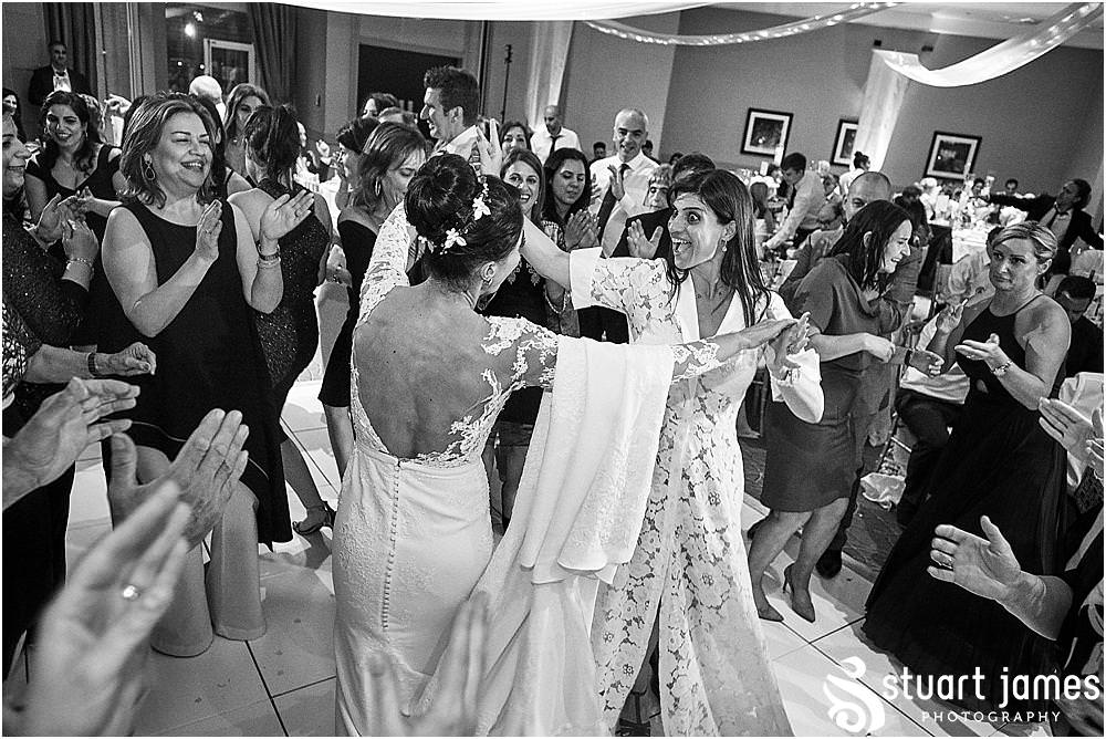 Great scenes as the guests really get into the party spirit at The Belfry in Birmingham by Greek Wedding Photographer Birmingham Stuart James