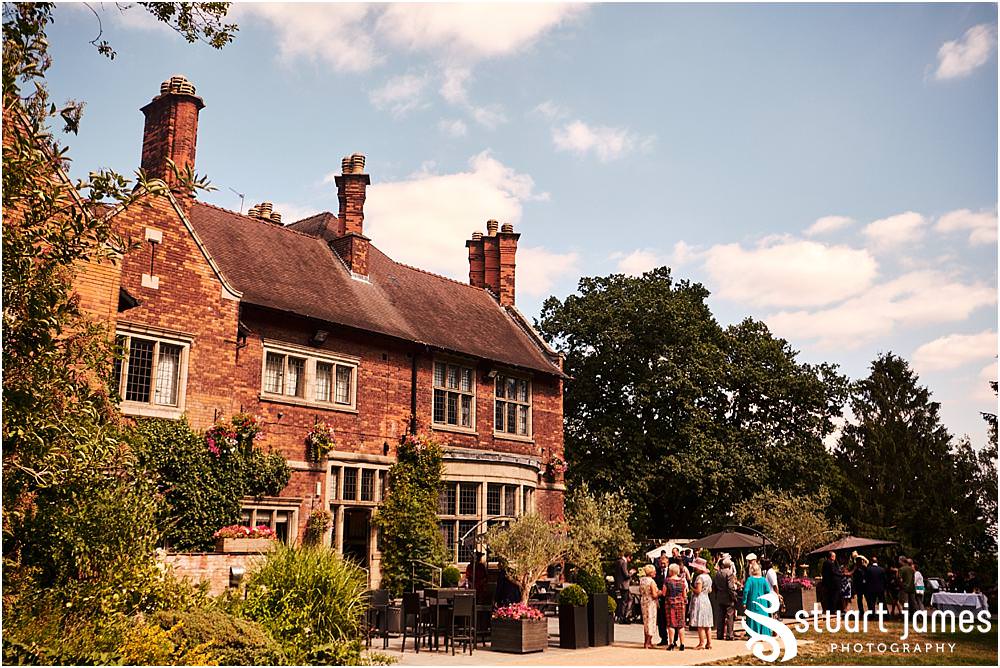 Fun candid photographs as the guests greet the new Mr & Mrs and enjoy the drinks reception on the lawns at Moxhull Hall in Sutton Coldfield by Moxhull Hall Wedding Photographer Stuart James