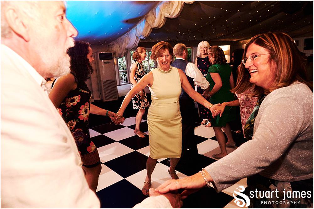 Capturing the fun of the reception as the guests love the ceilidh in the marquee at Moxhull Hall in Sutton Coldfield by Moxhull Hall Wedding Photographer Stuart James