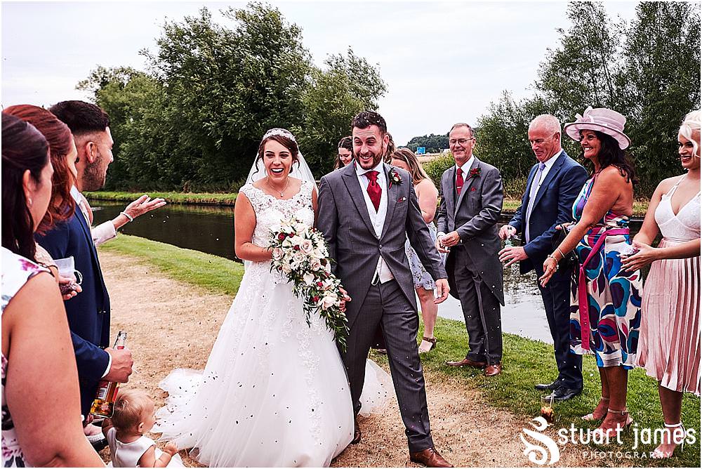 Confetti bombardment of our bride and groom on the canal bank at The Moat House by Stafford Wedding Photographers Stuart James